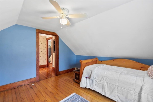 bedroom with wood-type flooring, ceiling fan, baseboards, and lofted ceiling