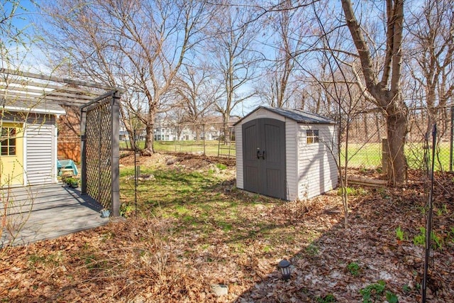 view of yard featuring a storage shed, a pergola, fence, and an outdoor structure