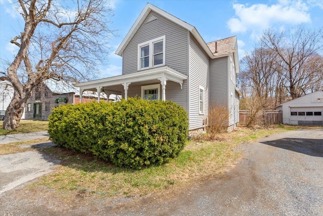 view of front of property featuring fence and an outdoor structure