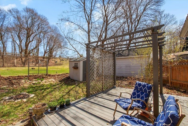 deck with a pergola, a storage shed, a fenced backyard, and an outbuilding