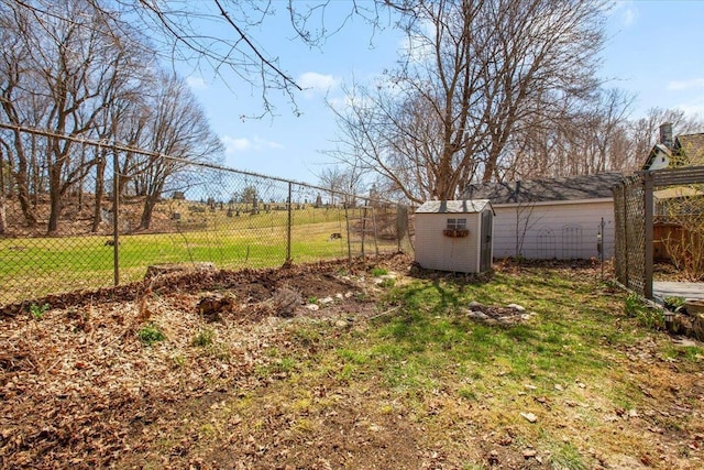 view of yard featuring fence, an outdoor structure, and a shed