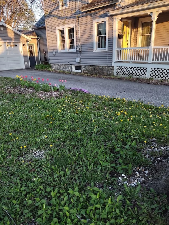 view of home's exterior with driveway, a porch, and a garage