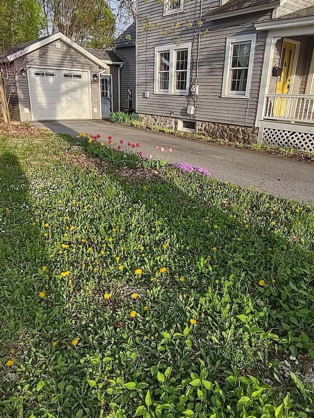 view of yard featuring an attached garage and concrete driveway