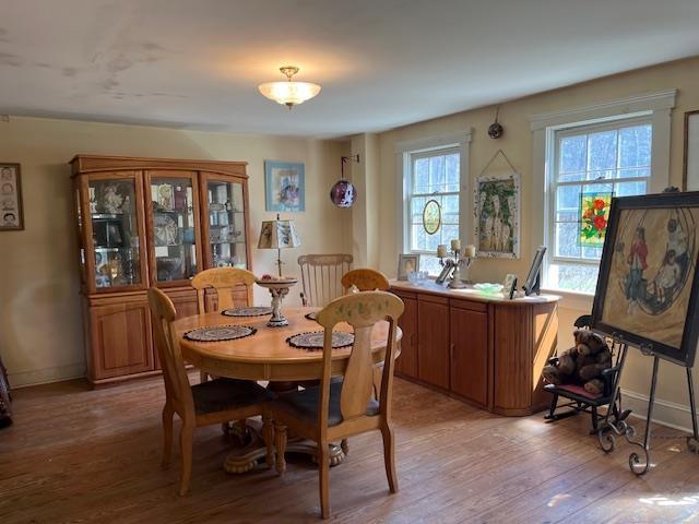 dining space featuring light wood-type flooring and baseboards