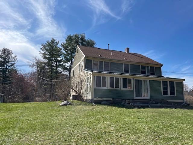 rear view of house with a lawn and a chimney