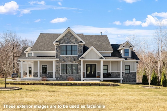 view of front of home featuring board and batten siding, covered porch, stone siding, a front lawn, and french doors