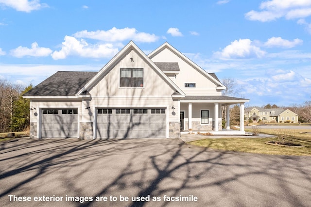 modern farmhouse with a porch, an attached garage, aphalt driveway, and stone siding