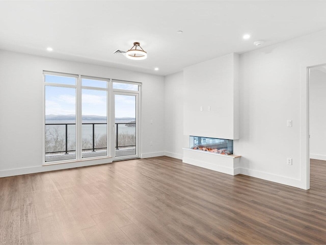 125 Cambrian Way Unit 605, Burlington, VT 05401 - unfurnished living room with a multi sided fireplace, recessed lighting, wood finished floors, and baseboards