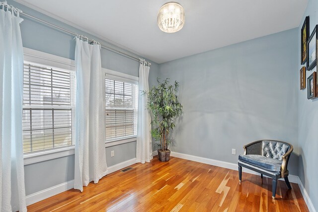 unfurnished room featuring light wood finished floors, visible vents, and baseboards
