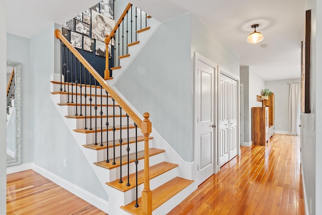 stairway with hardwood / wood-style flooring and baseboards