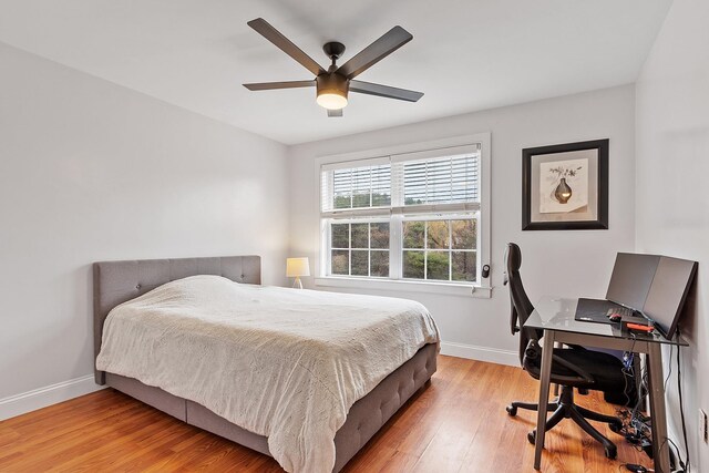 bedroom with light wood-type flooring, baseboards, and a ceiling fan