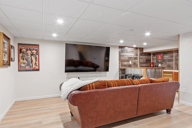 living area with light wood-style floors, bar area, baseboards, and recessed lighting