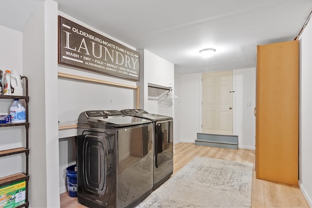 laundry area featuring light wood-style floors, washing machine and dryer, laundry area, and baseboards