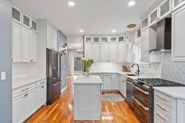 kitchen with tasteful backsplash, light countertops, light wood-style floors, appliances with stainless steel finishes, and a sink