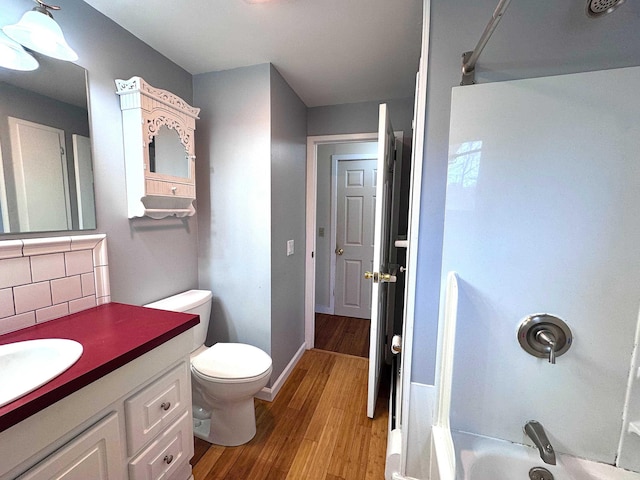 bathroom with decorative backsplash, shower / bath combination, wood finished floors, and vanity