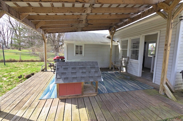wooden terrace with a yard, outdoor dining space, and fence