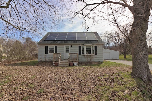 bungalow with roof mounted solar panels, a shingled roof, and a garage