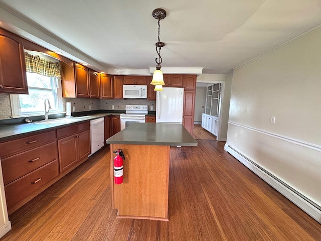kitchen featuring white appliances, a kitchen island, a sink, dark countertops, and a baseboard radiator