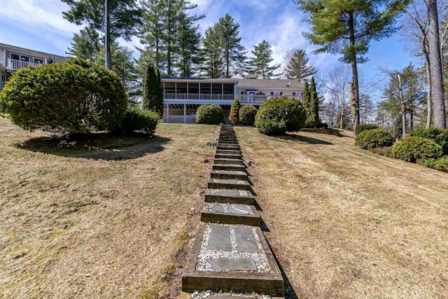 exterior space featuring a sunroom, a front lawn, and stairway
