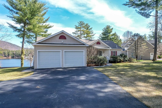 view of front of house featuring a front yard, a water view, a garage, and aphalt driveway