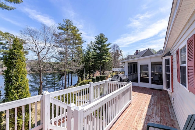 deck featuring a water view, a sunroom, and area for grilling