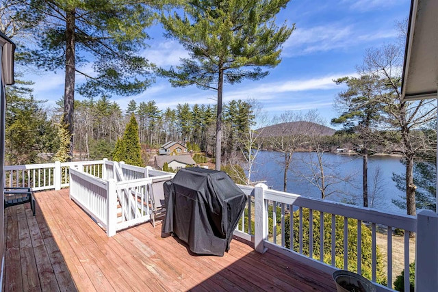 deck with a water view and a grill