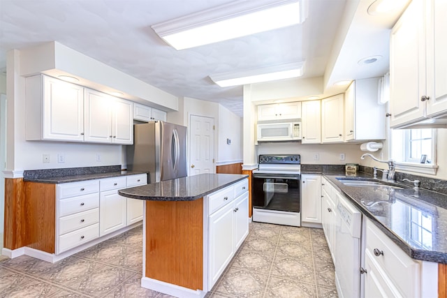 kitchen featuring a sink, a center island, white cabinetry, and white appliances