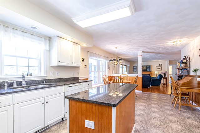 kitchen with a kitchen island, a sink, white dishwasher, and plenty of natural light