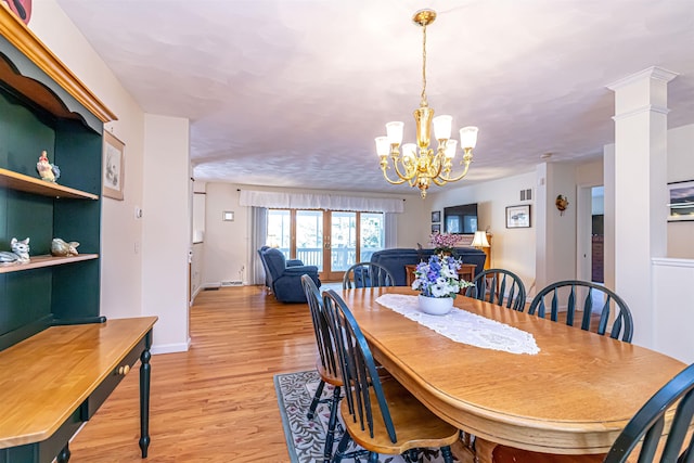 dining space with baseboards, a notable chandelier, and light wood-style floors