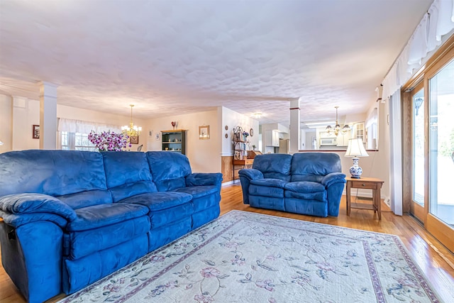 living room featuring a wealth of natural light, a notable chandelier, and wood finished floors