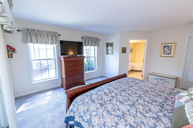 carpeted bedroom featuring baseboards and connected bathroom