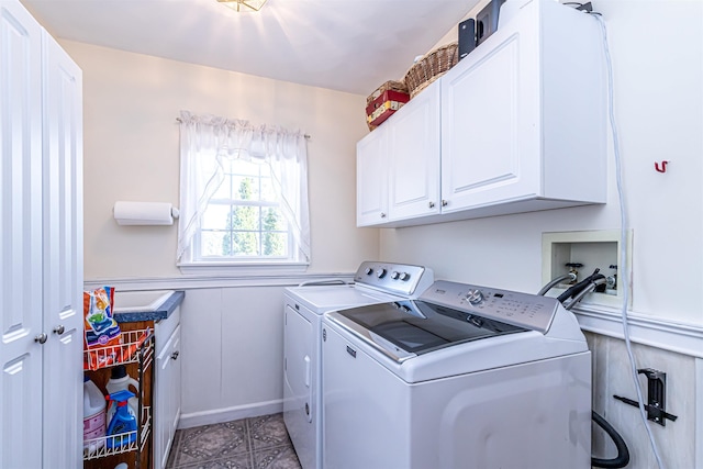 washroom with a decorative wall, wainscoting, cabinet space, washing machine and dryer, and light tile patterned flooring