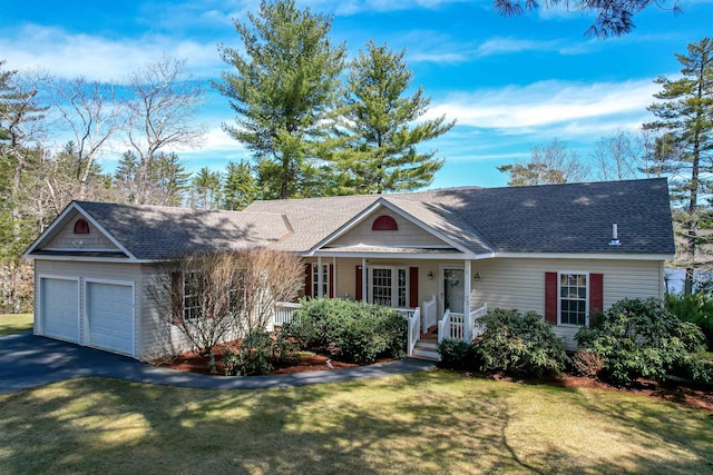 ranch-style house featuring a porch, a front lawn, an attached garage, a shingled roof, and driveway