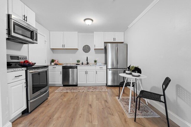 14 Strawberry Bank Rd Unit 2, Nashua, NH 03062 - kitchen with white cabinetry, appliances with stainless steel finishes, light wood-style floors, and crown molding