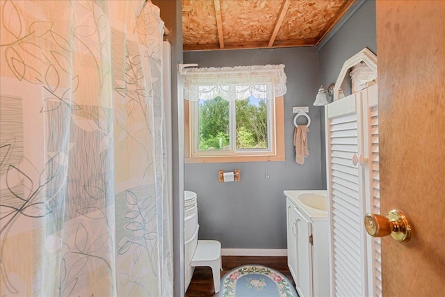 bathroom with toilet, curtained shower, vanity, and baseboards