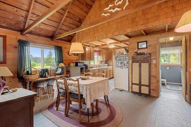dining space with wooden ceiling, wooden walls, and lofted ceiling with beams