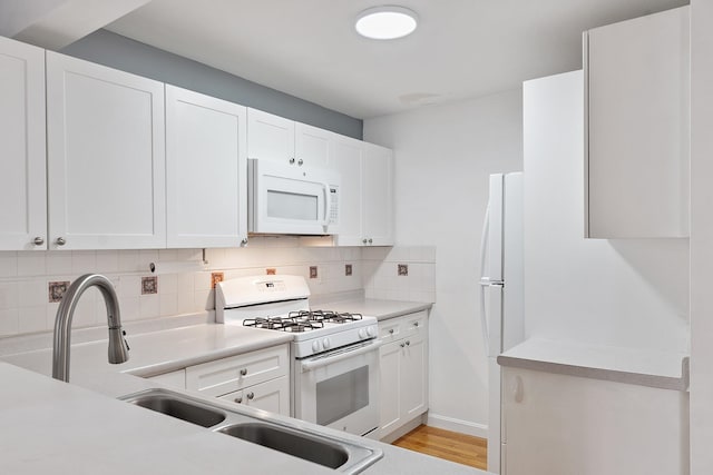 68 Barrington Ave, Nashua, NH 03062 - kitchen with white cabinets, a sink, light countertops, white appliances, and decorative backsplash