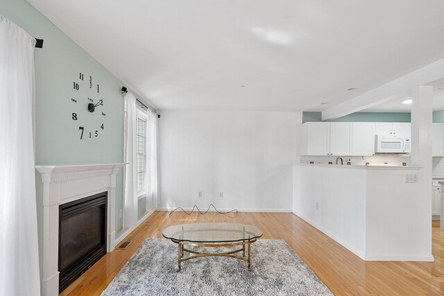 68 Barrington Ave, Nashua, NH 03062 - living area featuring light wood-style floors, baseboards, a glass covered fireplace, and visible vents