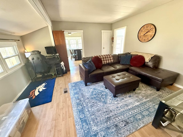 living area featuring visible vents, light wood-type flooring, and baseboards