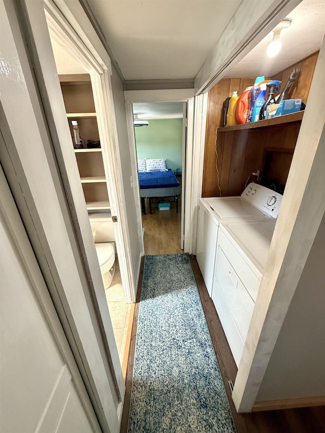 washroom featuring washing machine and dryer, laundry area, and wood finished floors