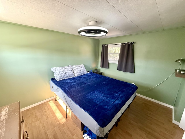bedroom with baseboards and wood finished floors