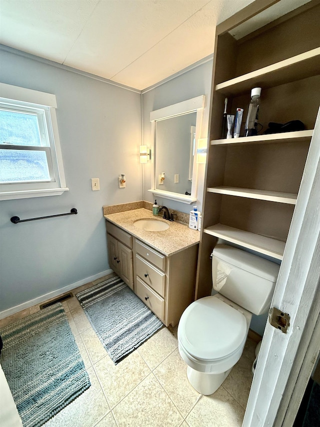 bathroom featuring visible vents, baseboards, toilet, vanity, and tile patterned floors