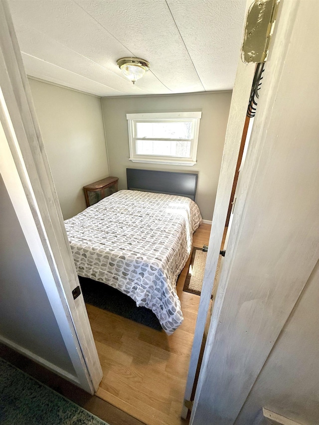 bedroom with wood finished floors and a textured ceiling