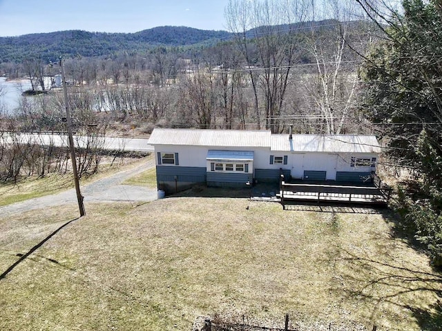 exterior space with a front yard, a view of trees, and a mountain view
