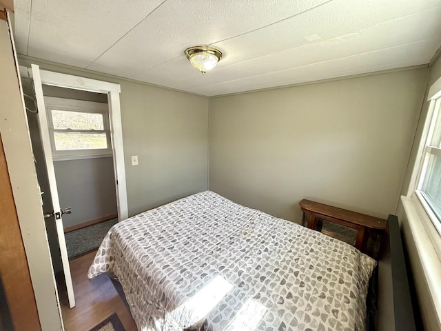 bedroom featuring a textured ceiling and dark wood finished floors