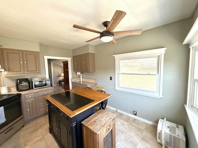 kitchen with light countertops, a ceiling fan, a kitchen island, a wall unit AC, and stainless steel appliances