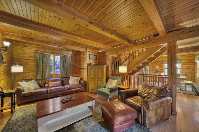 living area with wooden ceiling, wooden walls, beam ceiling, stairway, and hardwood / wood-style floors