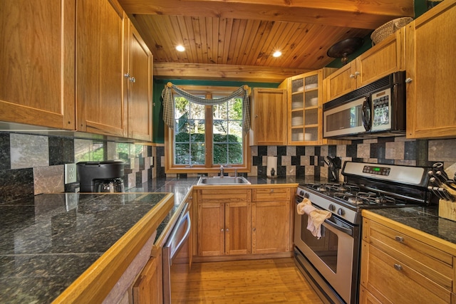 kitchen featuring light wood-style flooring, appliances with stainless steel finishes, wooden ceiling, a sink, and tile counters