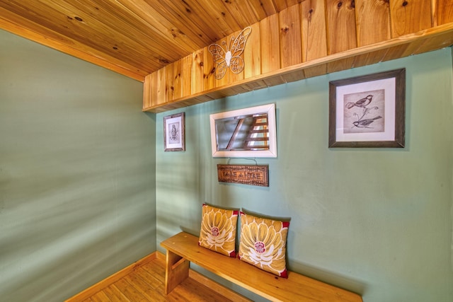 living area with wood ceiling, baseboards, and wood finished floors