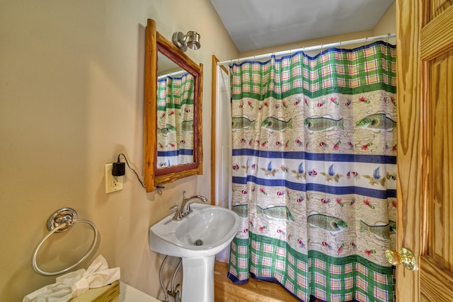 full bath with a shower with shower curtain and wood finished floors